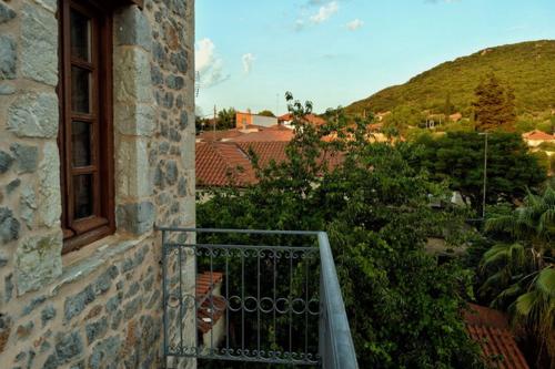 a balcony of a building with a window and a hill at Archontiko Leontari in Leondari