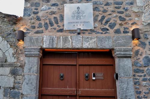 a stone building with a large wooden garage door at Archontiko Leontari in Leondari
