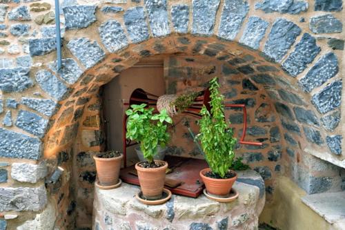 a stone oven with three potted plants on a table at Archontiko Leontari in Leondari
