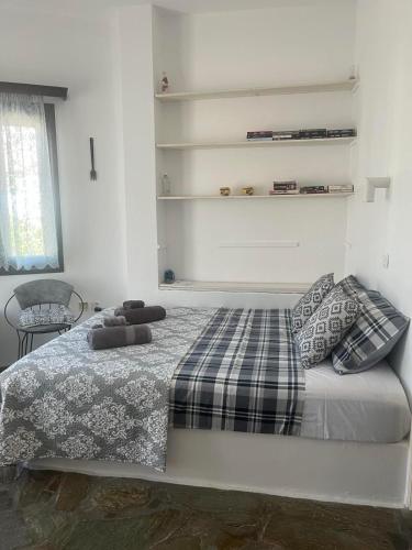 a bedroom with a bed with a plaid blanket at Cozy house by the sea in Batsi