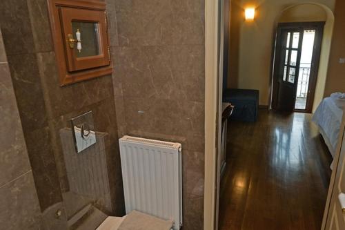 a room with a wall with a radiator and a hallway at Archontiko Leontari in Leondari