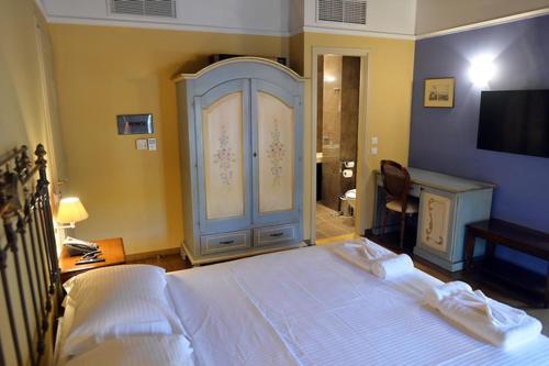a bedroom with a large white bed and a tv at Archontiko Leontari in Leondari