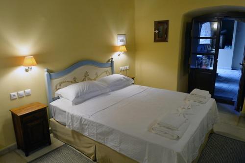 a bedroom with a large white bed in a room at Archontiko Leontari in Leondari