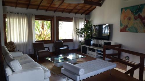 a living room with a white couch and a table at 3 Palmeiras Guest Lounge in Miguel Pereira