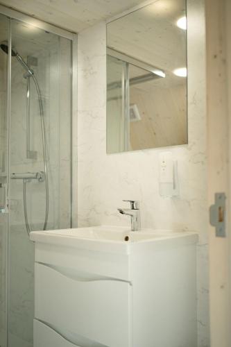 a white bathroom with a sink and a shower at Heaven Glamping - 300m from the Beach in Liepāja