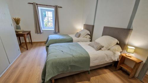 a bedroom with two beds and a window at Le Refuge de la Tardes in Champagnat