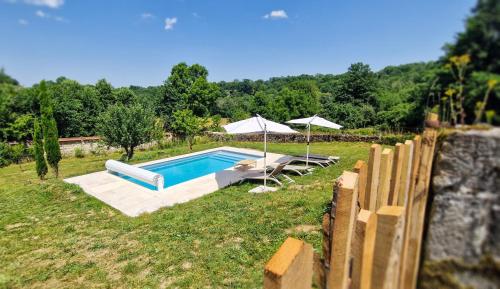 a swimming pool in a field next to a fence at Le Refuge de la Tardes in Champagnat