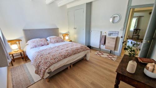 a bedroom with a large bed and a wooden floor at Le Refuge de la Tardes in Champagnat