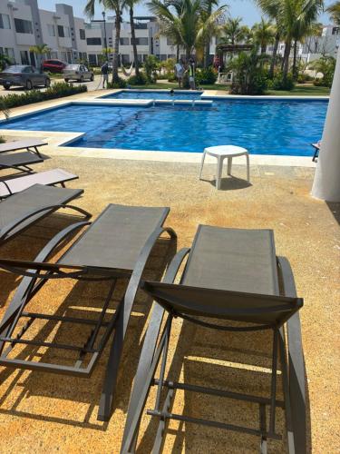 a group of tables and chairs next to a swimming pool at Acapulco Diamante in Cedro