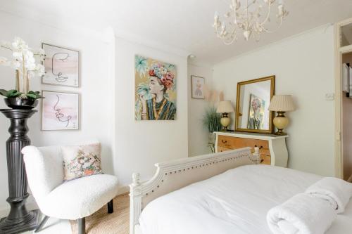 a bedroom with a bed and a chair and a chandelier at Writers Retreat in the heart of Ashford Town in Kent
