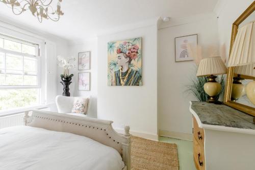 a bedroom with a bed and a painting on the wall at Writers Retreat in the heart of Ashford Town in Kent