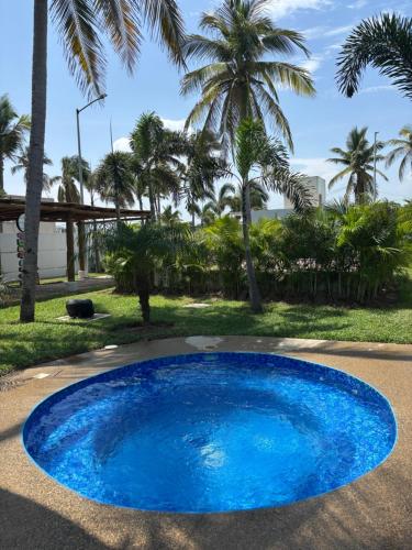 a large blue pool with palm trees in the background at Acapulco Diamante in Cedro