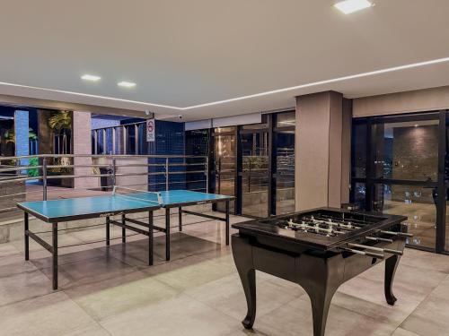 2 mesas de ping pong en una habitación con ventanas en Prédio com excelente custo benefício!, en Maceió