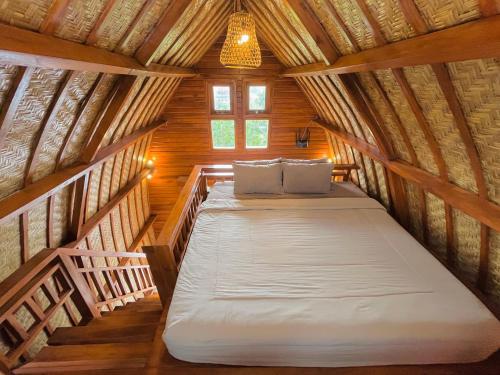 a bedroom with two beds in a wooden house at Murna House 1, Rooftop Balinese wooden house 360 sunrise to sunset view in Uluwatu