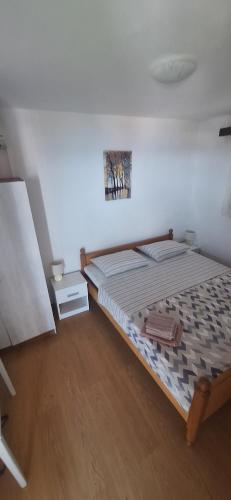 a bedroom with a large bed with a wooden floor at Apartman Mare BP in Dolac