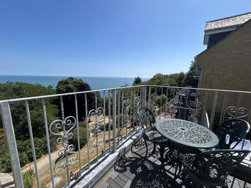 a balcony with a table and chairs and the ocean at Sea View in Shanklin