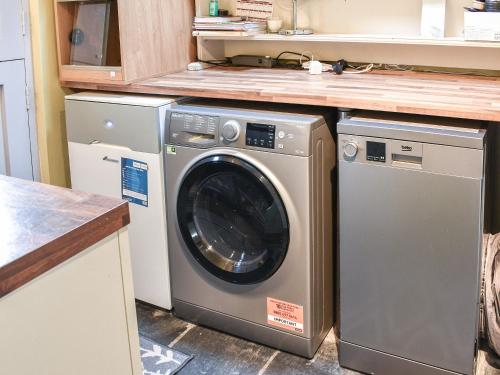 a washing machine and a washer and dryer in a kitchen at Summerhill Tanyrhos in Blaenau-Ffestiniog