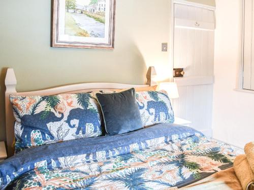 a bedroom with a bed with a blue comforter at Summerhill Tanyrhos in Blaenau-Ffestiniog