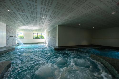 a large indoor pool with a water fountain at Nemea Appart Hotel Les Hauts de Milady Biarritz in Biarritz