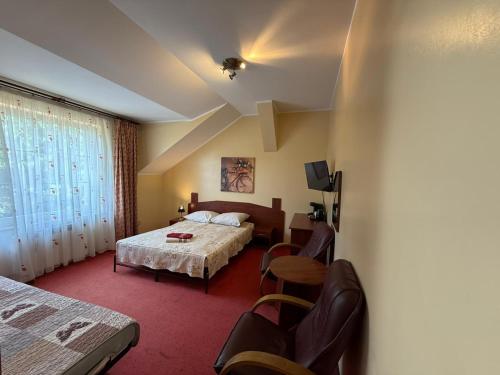 a hotel room with a bed and a table and chairs at Zatoka Leśna in Stare Olesno