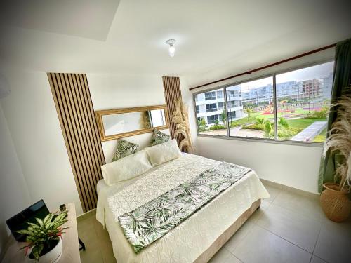 a bedroom with a bed and a large window at Serenity Flat in Puerto Tierrabaja