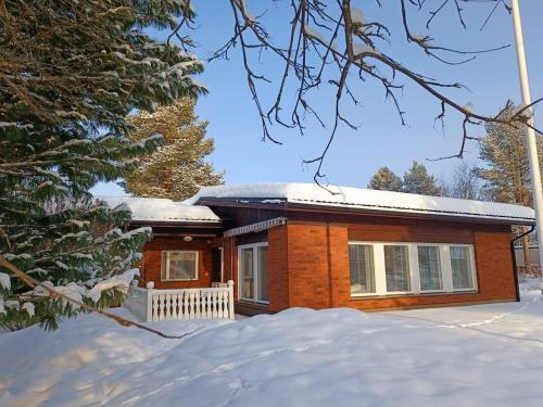 une petite maison en briques avec de la neige au sol dans l'établissement Resort Selekosten Tunto, à Rovaniemi
