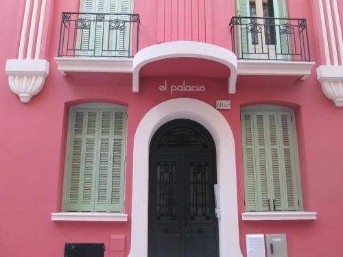 a pink building with a black door and windows at Quiet flat center Monaco in Monte Carlo