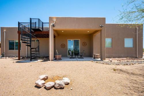 a building with a spiral staircase and rocks in front of it at Spacious 3BR Retreat - Mtn Views & BBQ in Apache Junction
