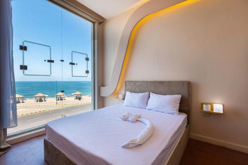 a bedroom with a bed with a view of the beach at Hayah Suites & Rooms in Alexandria