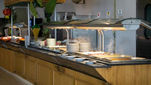 a buffet line in a restaurant with plates and food at Golf Residence- Families and Couples Only in Hammam Sousse