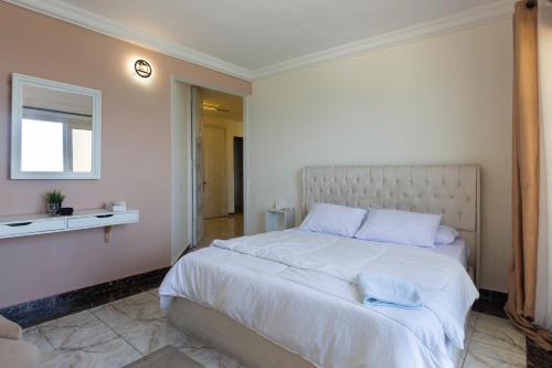 a bedroom with a large white bed and a window at Hayah Suites & Rooms in Alexandria