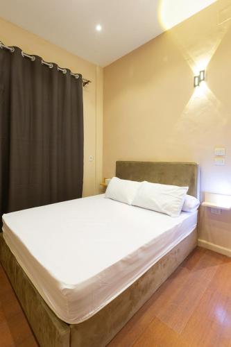 a large bed with white sheets in a room at Hayah Suites & Rooms in Alexandria