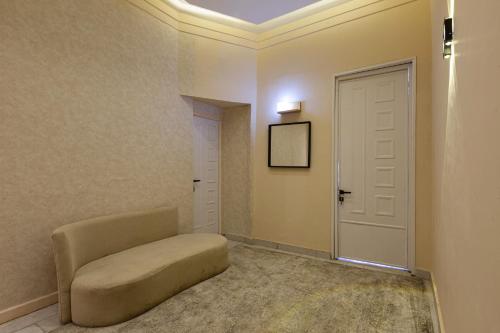 a living room with a chair and a door at Hayah Suites & Rooms in Alexandria