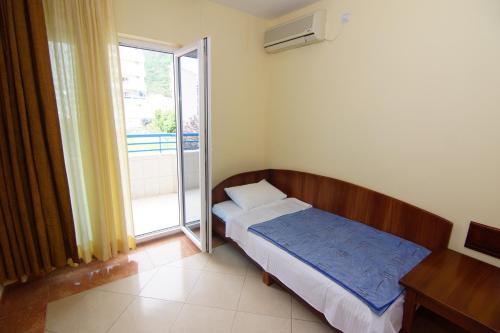 a small bedroom with a bed and a window at Blue Palace Guest House in Budva