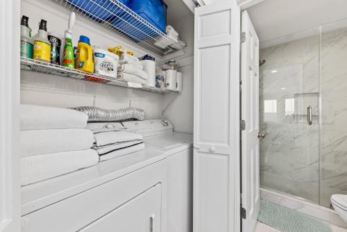 y baño con ducha y toallas blancas. en 1935 Bohicket Marina, en Seabrook Island