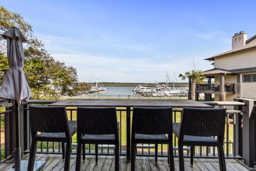 a table and chairs on a deck with a marina at 1935 Bohicket Marina in Seabrook Island