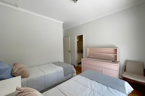 a white room with two beds and a tv at Mansão com Piscina | Conforto e Exclusividade in Cotia