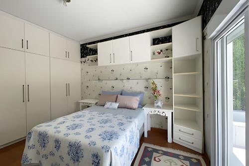 a small bedroom with a bed and a desk at Mansão com Piscina | Conforto e Exclusividade in Cotia