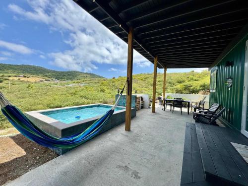 a porch with a hammock and a swimming pool at The Hangover Block in Culebra