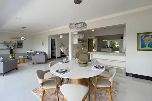 a living room with a white table and chairs at Mansão com Piscina | Conforto e Exclusividade in Cotia