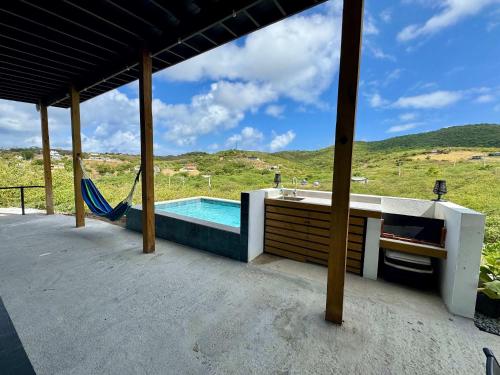 a house with a swimming pool and a hammock at The Hangover Block in Culebra