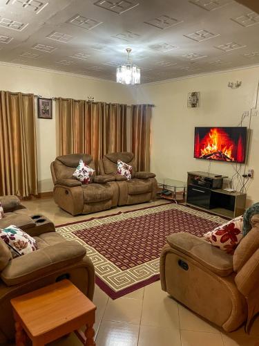a living room with two couches and a fireplace at Nyamataro Bungalow in Kisii