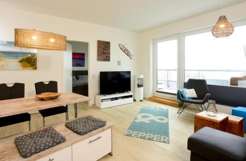 a living room with a table and a tv at Marina Loft in Kappeln