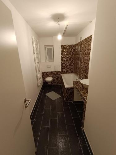 a bathroom with two sinks and a tub and a toilet at Spacious Flat with 3 bedooms for 5-8 guests in Zeitz