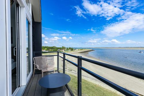 a balcony with a chair and a view of the water at Vakantiewoning aan het water - met 4 balkons - Vista Maris - Nr 30 in Sint Annaland