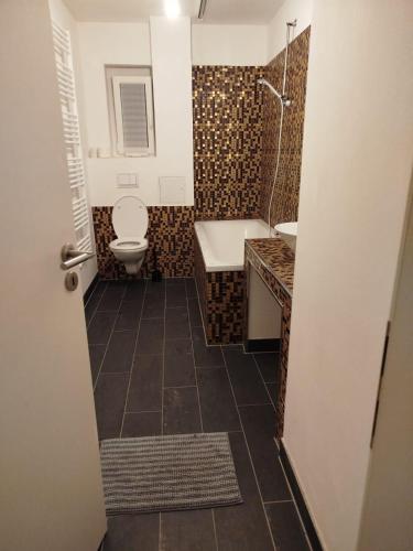 a bathroom with a toilet and a sink and a tub at Spacious Flat with 3 bedooms for 5-8 guests in Zeitz