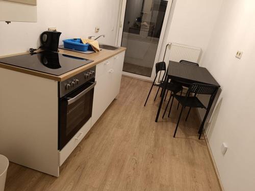a kitchen with a stove and a table with chairs at Spacious Flat with 3 bedooms for 5-8 guests in Zeitz