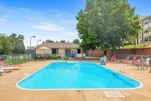 a large swimming pool with chairs and a tree at Little House on the Fairway- Luxury Golf Condo in Branson