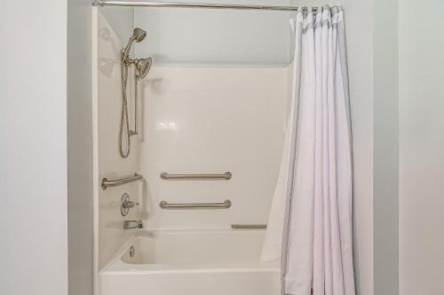 a bathroom with a shower with a white shower curtain at Steps to Smith Mountain Lake Unit with Pool Access! in Huddleston