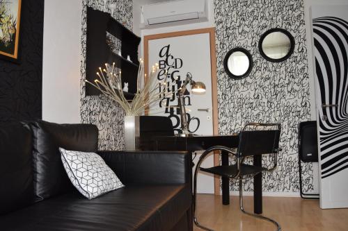 a living room with a black couch and a mirror at Les Chambourlettes in Mons